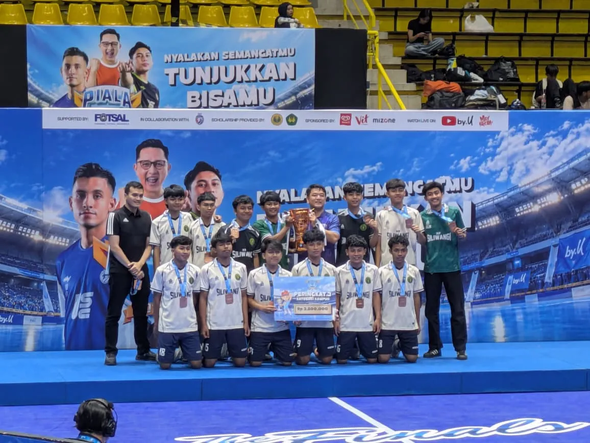 Foto bersama tim futsal IKIP Siliwangi di podium bersama piala dan penghargaan Peringkat 3 Kategori Kampus